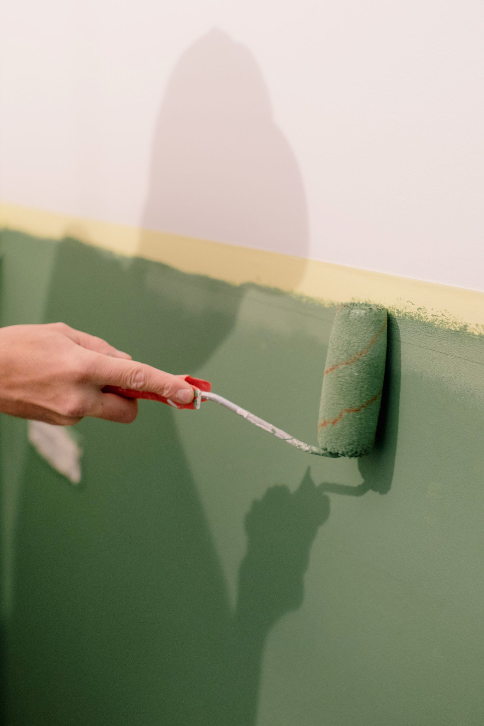Interior wall painting with a roller in a bright apartment