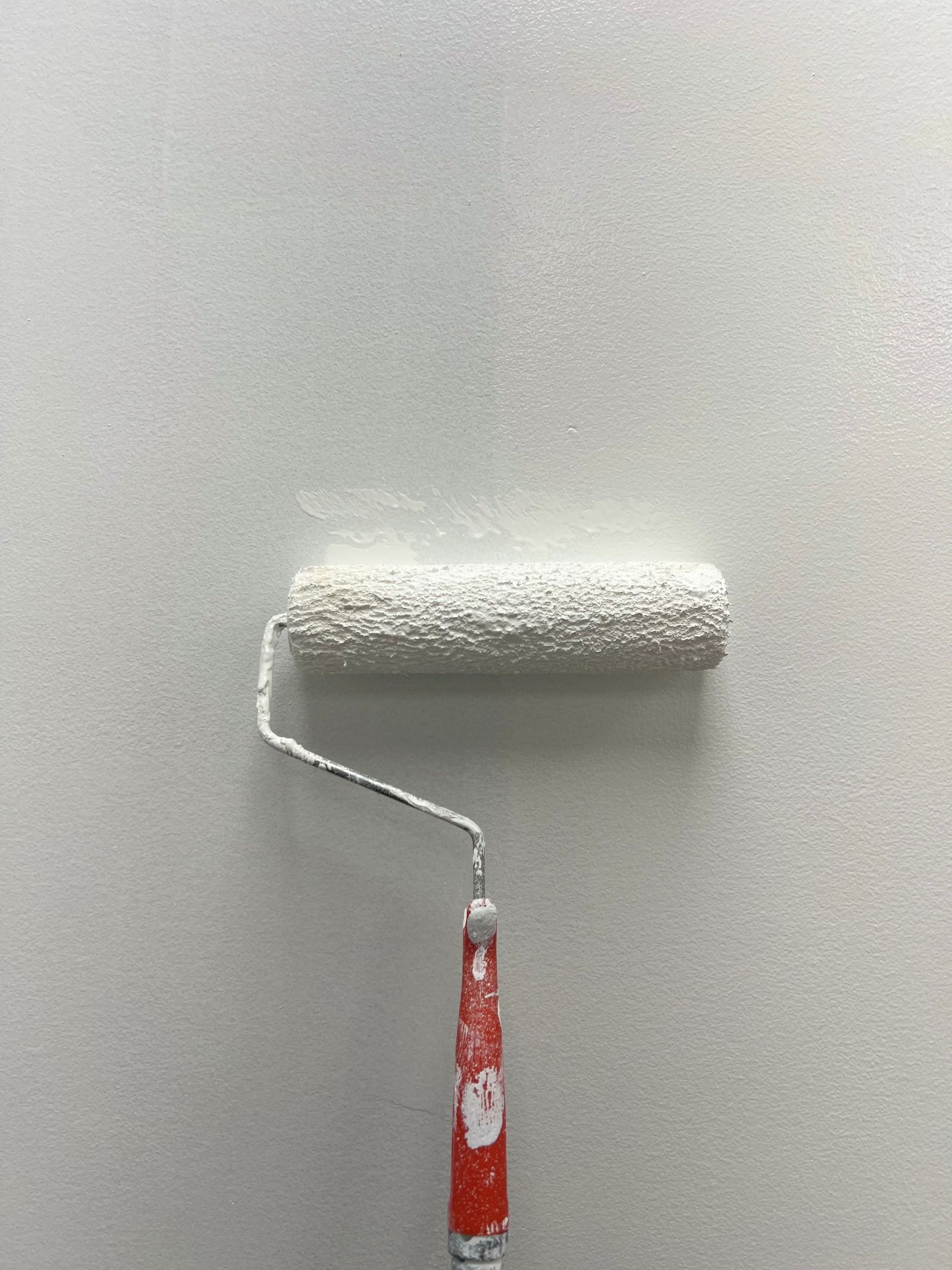 Paint roller applying a fresh coat on an interior wall